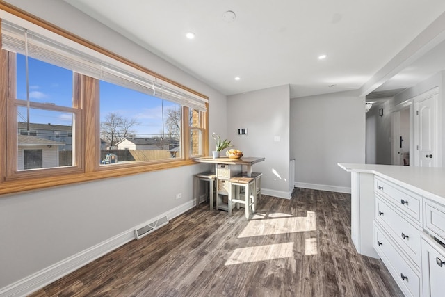 interior space with dark wood finished floors, visible vents, recessed lighting, and baseboards