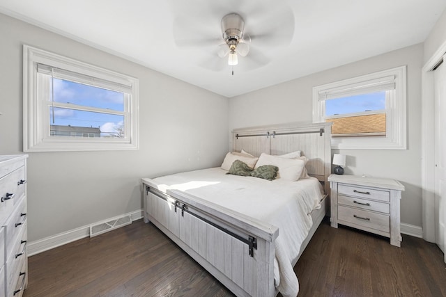 bedroom with visible vents, baseboards, dark wood finished floors, and a ceiling fan