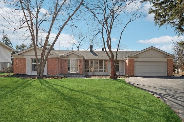 ranch-style house featuring brick siding, a front yard, a chimney, a garage, and driveway