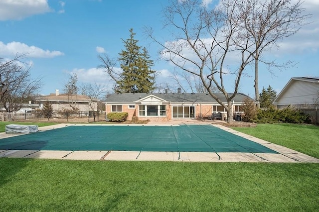 rear view of house with fence, a lawn, and a fenced in pool