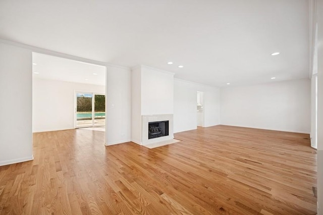 unfurnished living room with crown molding, a fireplace with flush hearth, recessed lighting, and light wood-type flooring