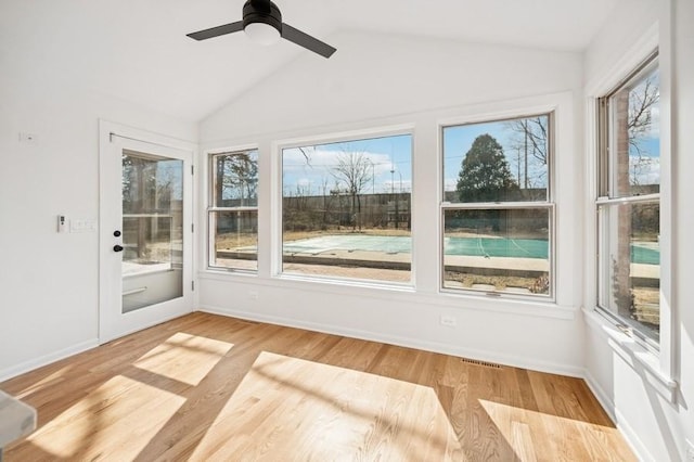 unfurnished sunroom with lofted ceiling, a ceiling fan, and visible vents