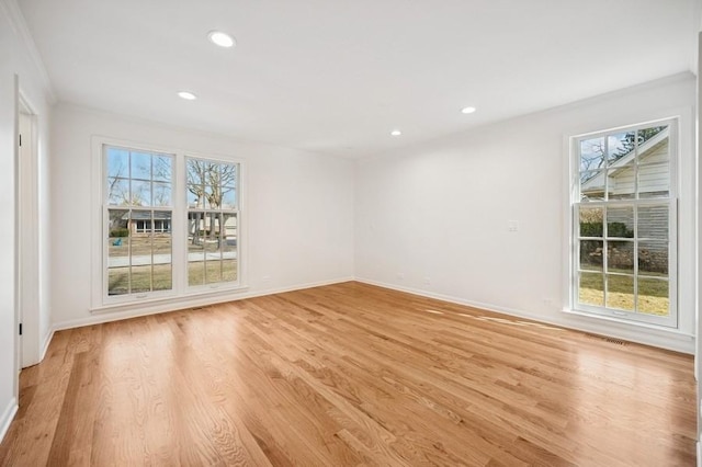 unfurnished room with light wood finished floors, plenty of natural light, and recessed lighting