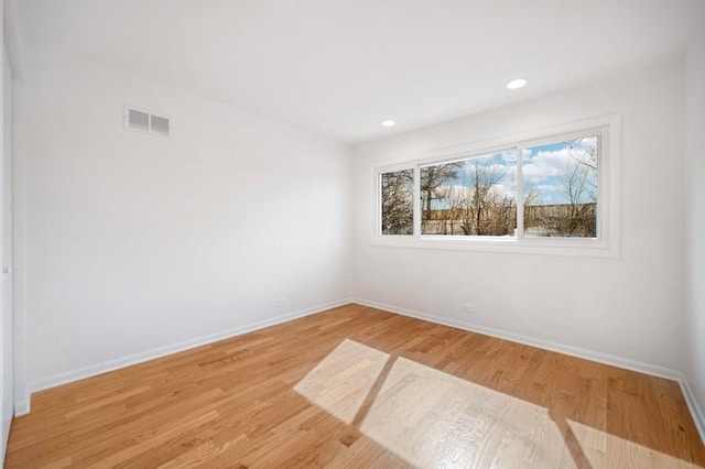 empty room with visible vents, recessed lighting, light wood-type flooring, and baseboards