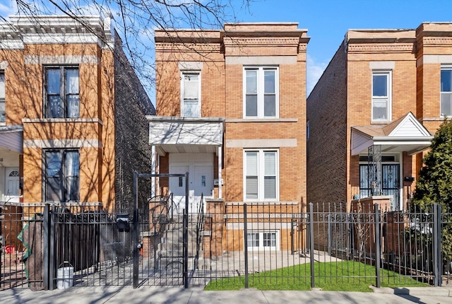 view of front of property with a fenced front yard, brick siding, and a gate