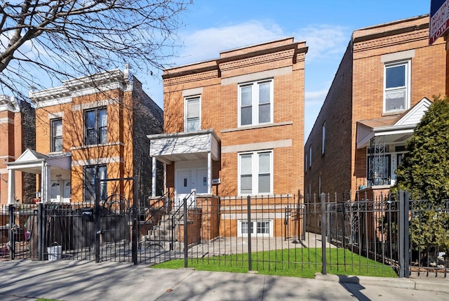 view of front facade with brick siding, a fenced front yard, and a gate