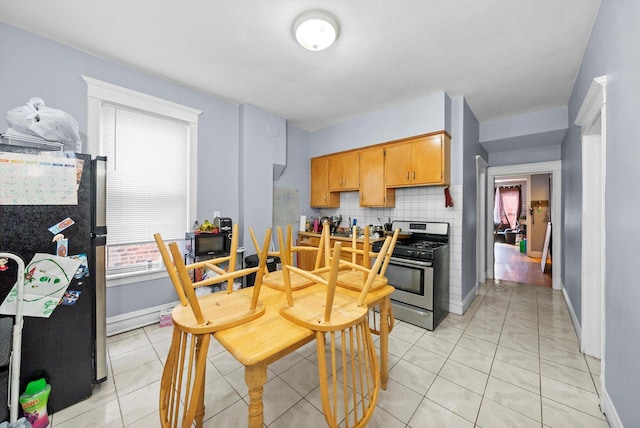 2434 W Pershing Rd, Chicago, IL 60632 - kitchen featuring stainless steel appliances, baseboards, light tile patterned flooring, and decorative backsplash