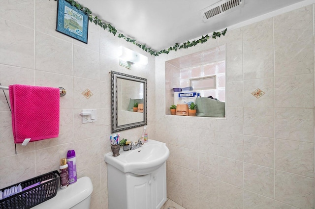 2434 W Pershing Rd, Chicago, IL 60632 - half bath featuring visible vents, vanity, toilet, and tile walls