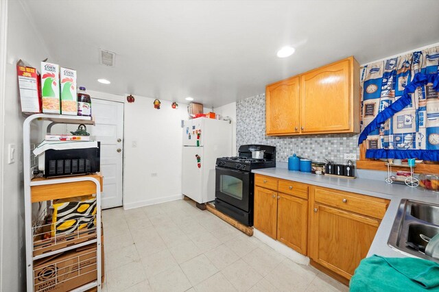 2434 W Pershing Rd, Chicago, IL 60632 - kitchen with visible vents, tasteful backsplash, freestanding refrigerator, gas stove, and light countertops
