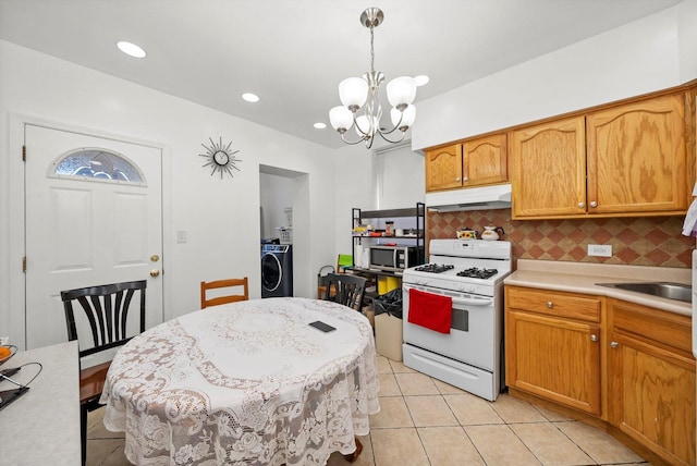 2434 W Pershing Rd, Chicago, IL 60632 - kitchen featuring stainless steel microwave, white gas stove, under cabinet range hood, light countertops, and a sink