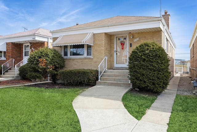 bungalow featuring a front lawn, brick siding, and a chimney