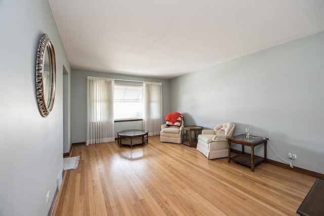 living area with light wood-type flooring and baseboards