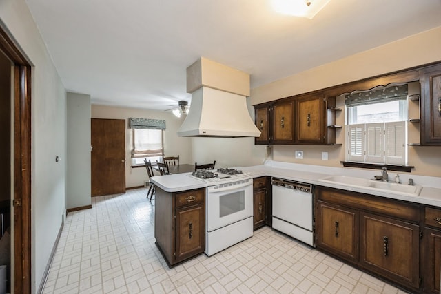 kitchen featuring a sink, white appliances, a peninsula, custom exhaust hood, and ceiling fan