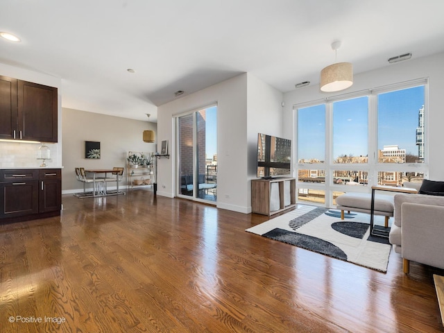 living area with wood finished floors, baseboards, and a wealth of natural light