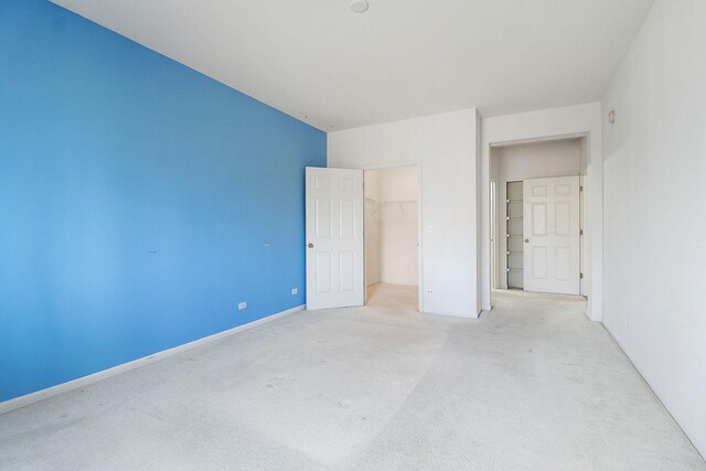 unfurnished bedroom with a closet, baseboards, and carpet