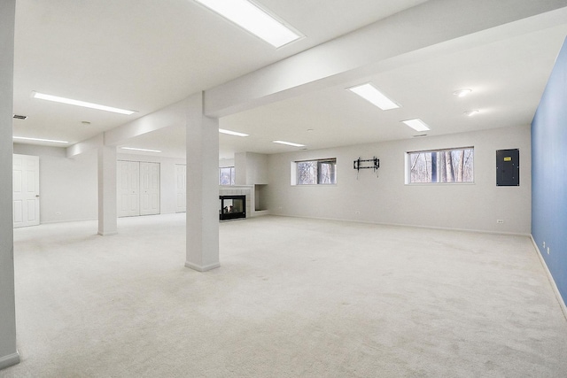 basement with electric panel, a fireplace, baseboards, and carpet floors