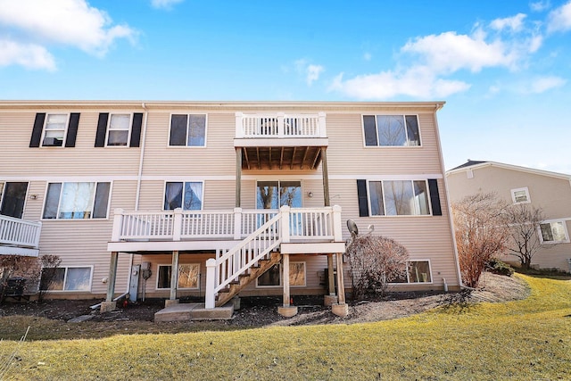 back of property with stairway, a wooden deck, and a yard