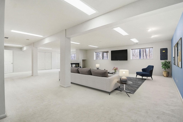 living area with a multi sided fireplace, baseboards, and carpet floors