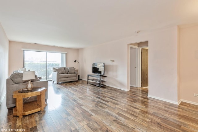 living area with baseboards and wood finished floors