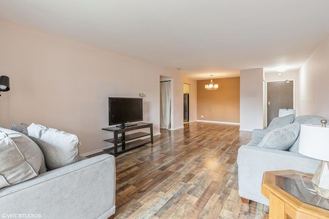 living area with wood finished floors, baseboards, and a chandelier