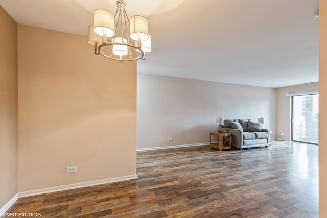 interior space featuring a chandelier, baseboards, and dark wood finished floors