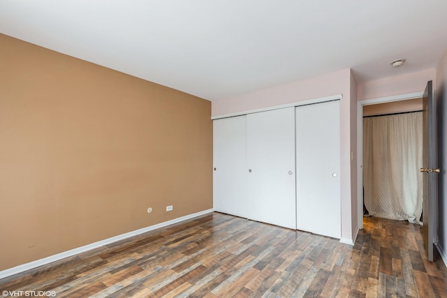 unfurnished bedroom with a closet, baseboards, and wood finished floors