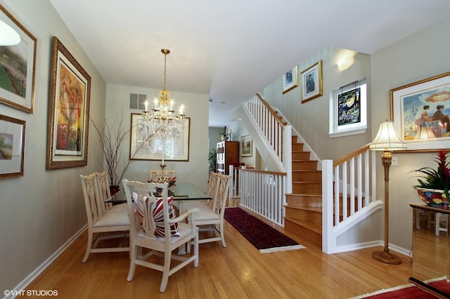 1616 S Indiana Ave Unit A2, Chicago, IL 60616 - dining space featuring wood finished floors, visible vents, baseboards, stairway, and a chandelier