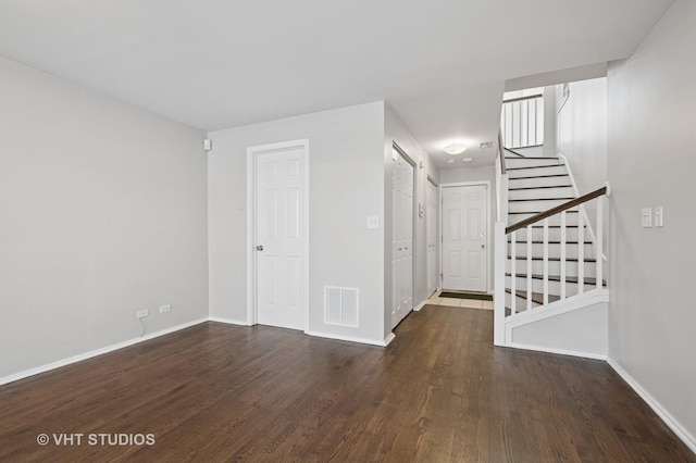 interior space with baseboards, visible vents, wood finished floors, and stairway