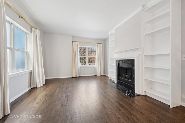 unfurnished living room with baseboards, a fireplace, a notable chandelier, and dark wood-type flooring