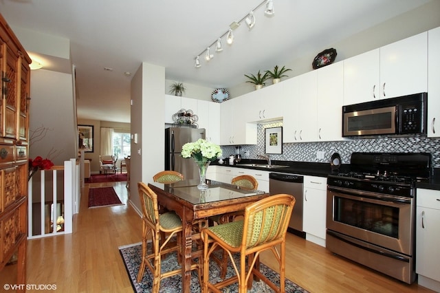 1616 S Indiana Ave Unit A2, Chicago, IL 60616 - kitchen featuring dark countertops, light wood-style flooring, appliances with stainless steel finishes, and a sink
