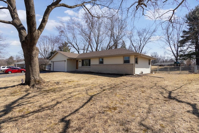 ranch-style home with brick siding, a garage, and fence