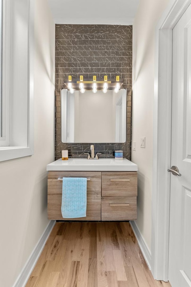 bathroom with vanity, wood finished floors, and baseboards