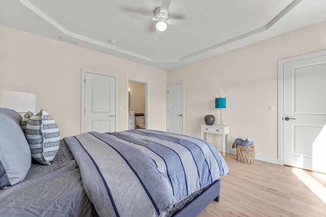 bedroom featuring baseboards, a raised ceiling, ceiling fan, and light wood finished floors