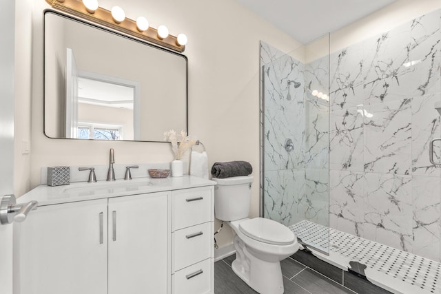 bathroom with vanity, toilet, and a marble finish shower