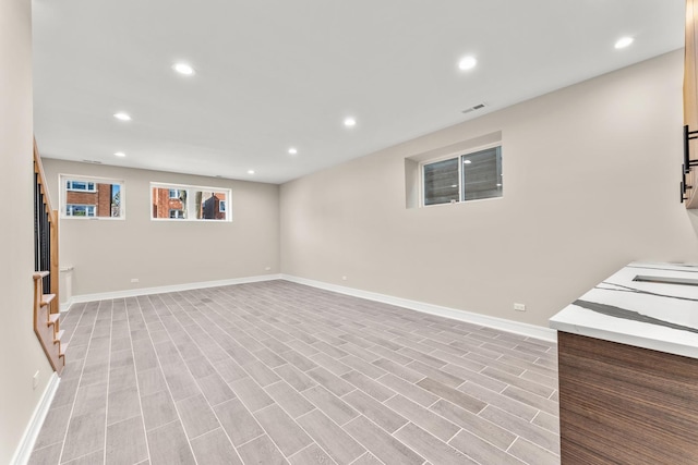 below grade area featuring visible vents, recessed lighting, stairs, and baseboards