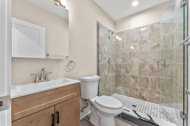 full bath with vanity, a shower stall, and toilet