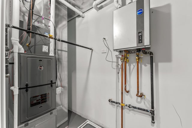 utility room featuring heating unit and water heater