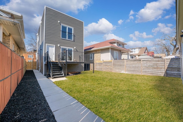 back of house with a yard, stairway, a wooden deck, and a fenced backyard