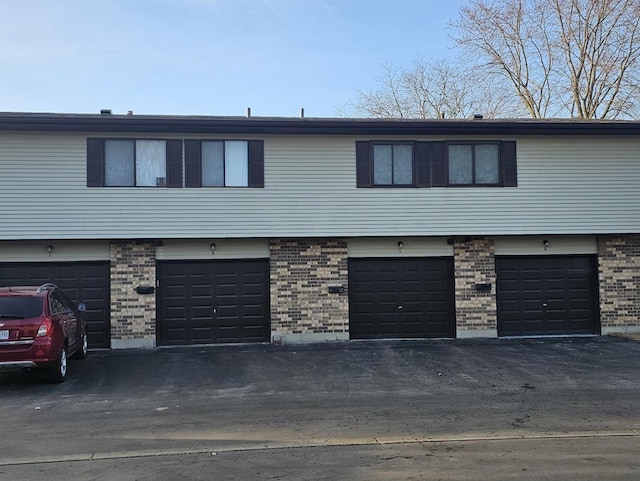 view of property with an attached garage and brick siding