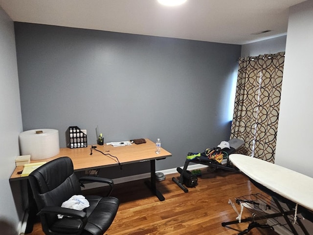 office featuring visible vents, baseboards, and wood finished floors