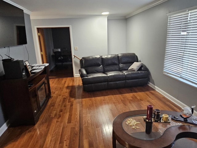 living area with hardwood / wood-style floors, crown molding, and baseboards