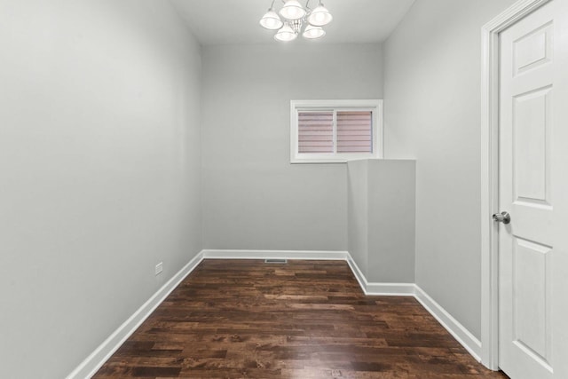 interior space featuring an inviting chandelier, baseboards, and dark wood-type flooring