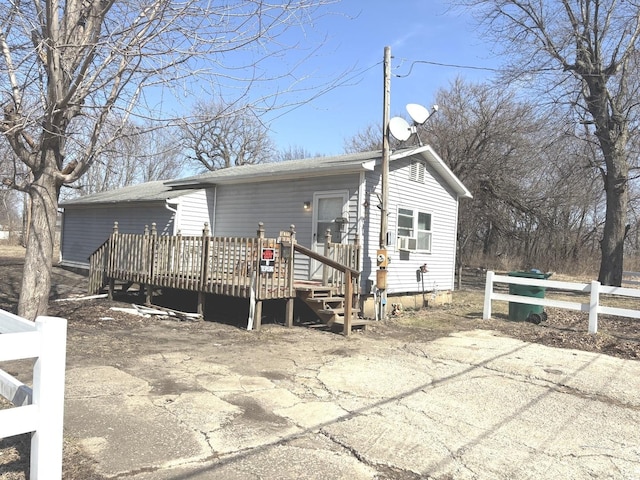 rear view of house featuring cooling unit, a deck, and fence