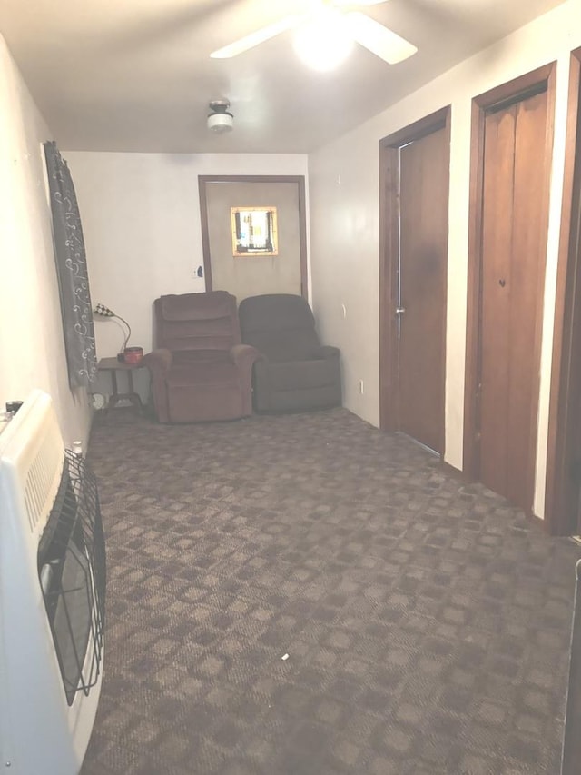 carpeted living room featuring heating unit and a ceiling fan