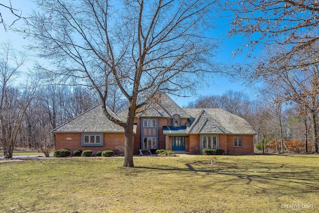 view of front of home with a front lawn and brick siding