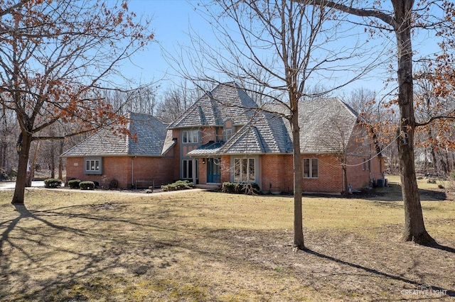 view of front facade with a front yard and brick siding