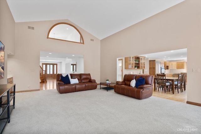 living room with light colored carpet, visible vents, and baseboards