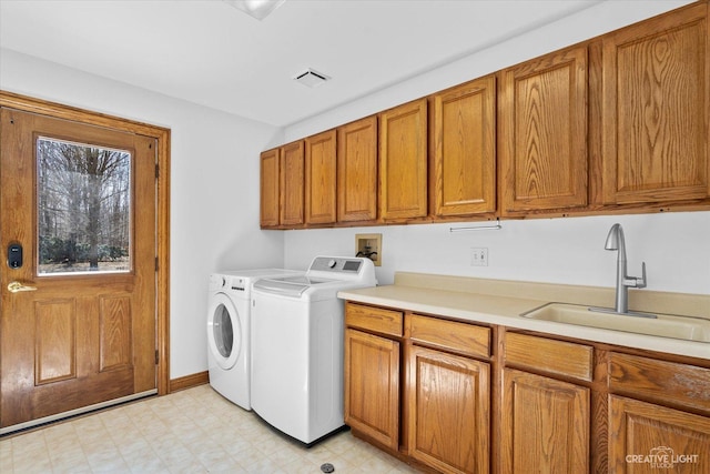 washroom featuring visible vents, a sink, cabinet space, separate washer and dryer, and light floors