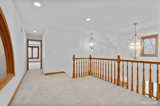 corridor with visible vents, baseboards, carpet floors, recessed lighting, and a chandelier