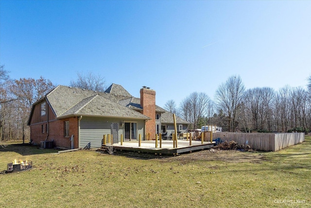 back of property featuring central AC unit, fence, a yard, a deck, and brick siding